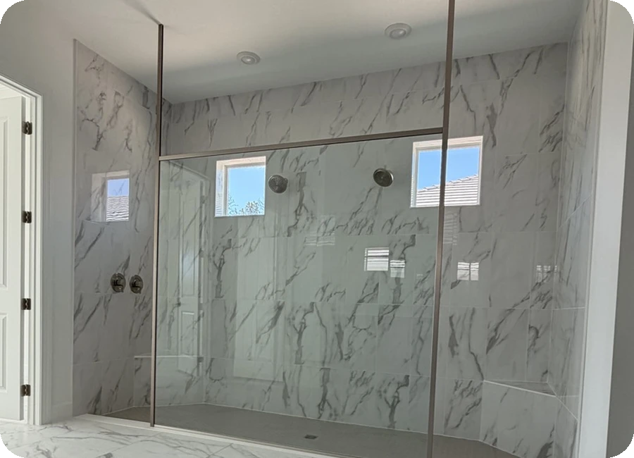 Calacatta marble porcelain shower with frameless glass panel and matching floor tile